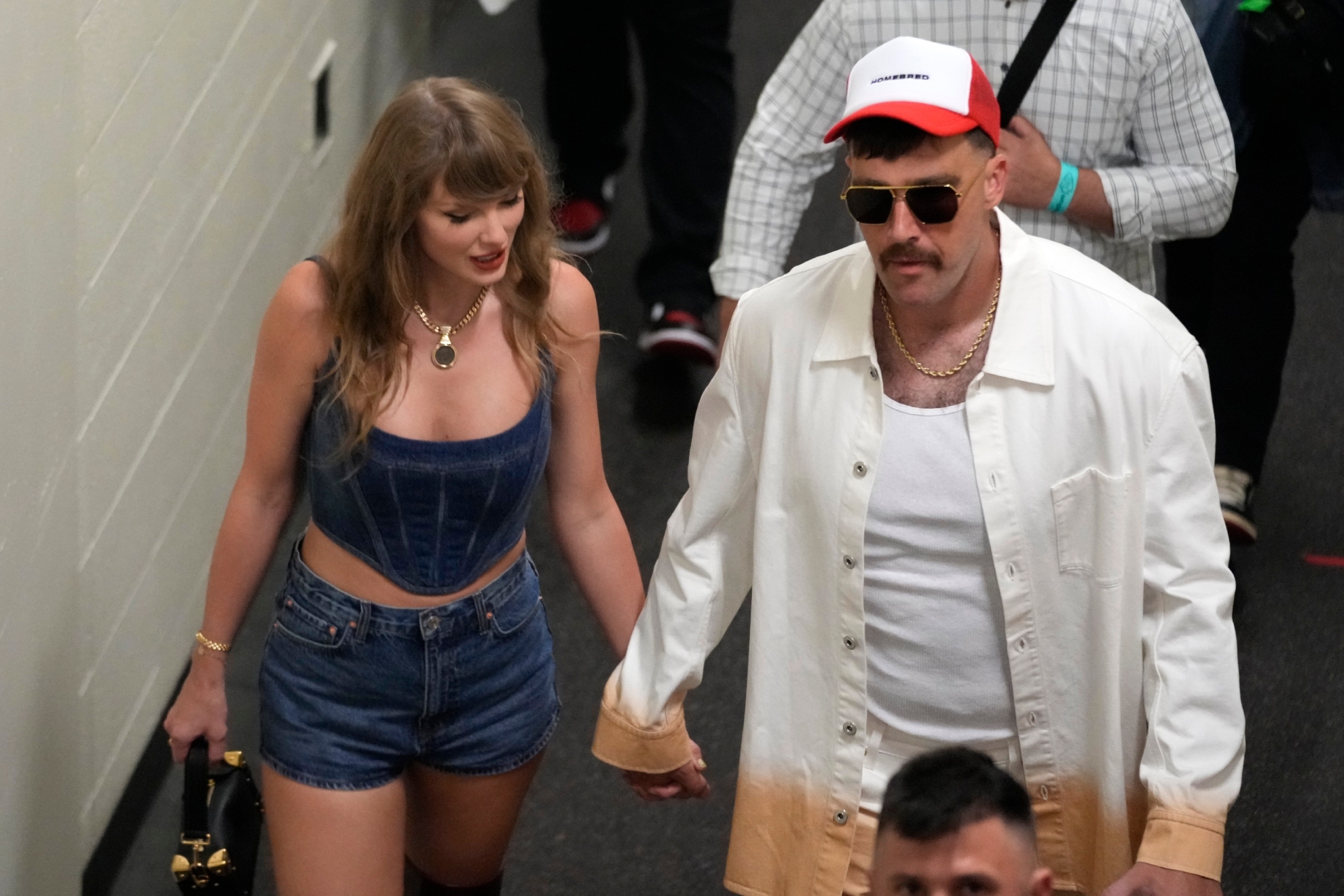 Kansas City Chiefs tight end Travis Kelce, right, and Taylor Swift hold hands following an NFL football game between the Chiefs and the Baltimore Ravens